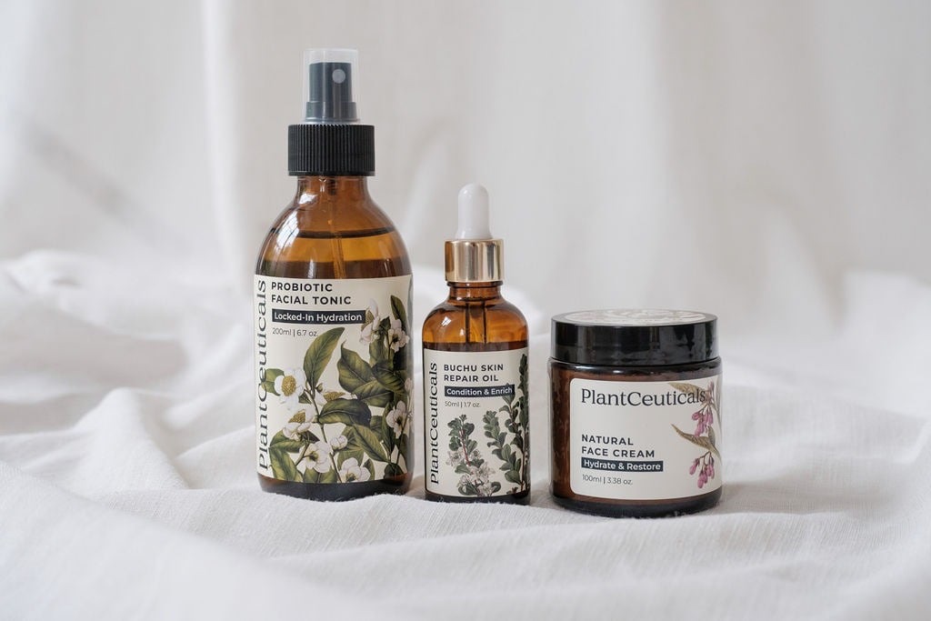 PlantCeuticals probiotic facial tonic, buchu skin repair oil and natural face cream styled on white linen.