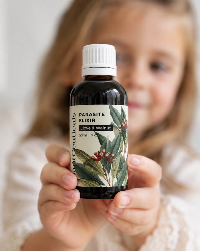 Child holding a PlantCeuticals Clove and Walnut Parasite Elixir bottle.